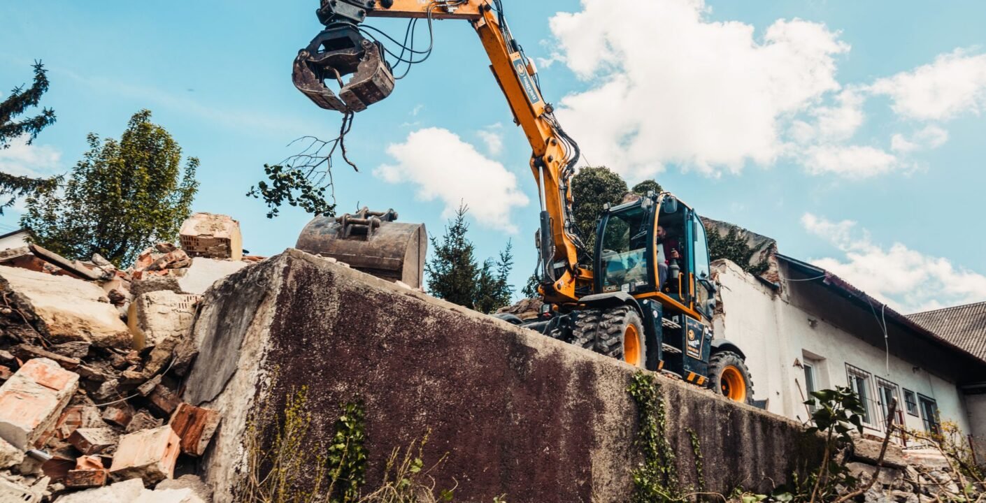 Bagger mit Abbruchzange bei Abrissarbeiten an einem Gebäude